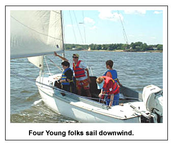 Four teen sailors sail downwind in Ensign.