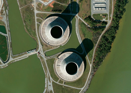 Natural-draft cooling towers and one of two intake screens and associated pumps for the Tennessee Valley Authority, Sequoyah Nuclear Power Plant, Tennessee. Natural-draft tower airflow is drawn through the packing or fill (distributed at the base) by means of the small density difference between the warm moist air inside the tower and the cooler ambient air outside the tower (Stultz and Kitto, 1992). Because of the small temperature and density difference, these cooling towers tend to be tall. These towers are relatively open cylindrical structures. Modern units are sometimes referred to as hyperbolic towers because of their shape. The heat rejected from the steam to the cooling water is circulated through the cooling tower where the heat is rejected to the atmosphere as latent and sensible heat.