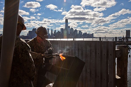 U.S. Navy Seabee works to repair pier facilities in Hobobken, N.J. The U.S. Navy has positioned forces in the area to assist U.S. Northern Command (NORTHCOM) in support of FEMA and local civil authorities following the destruction caused by Hurricane Sandy. (U.S. Marine Corps photo by Cpl. Bryan Nygaard/Released)