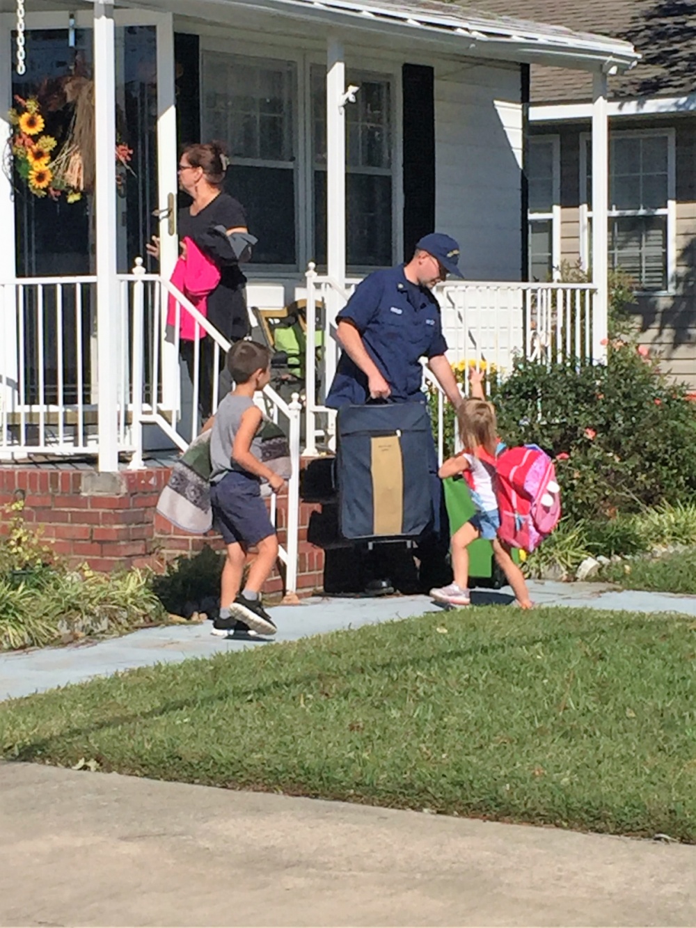 Petty Officer 1st Class James Prosser is reunited with his children in Lumberton, North Carolina, Oct. 16, 2016. Prosser received help from various rescue agencies and traversed flood waters to reach them. (U.S. Coast Guard photo by Master Chief Petty Officer Louis Coleman/Released)