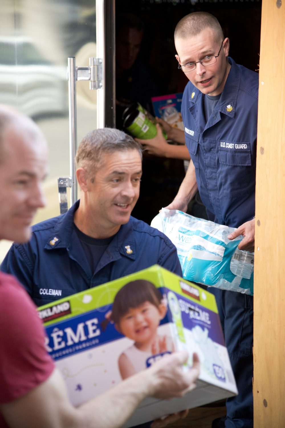 Petty Officer 1st Class James Prosser (right) and Master Chief Petty Officer Louis Coleman unload donated staples from Coleman's trailer in Lumberton, North Carolina, Oct. 16, 2016. Prosser organized the donations of food, water and other necessities for Lumberton residents impacted by floodwaters after Hurricane Matthew. (U.S. Coast Guard photo by Petty Officer 2nd Class Nate Littlejohn/Released)